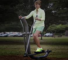 Woman exercising on an Elliptical machine at an Outdoor Fitness Park